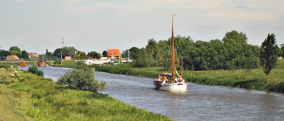 Ein Segelboot auf der Pinnau, von der Terrasse aus gesehen